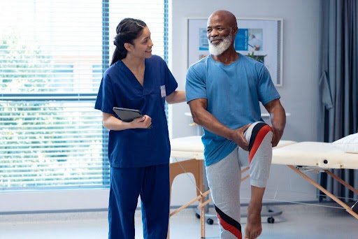 Physiotherapist guiding a patient through a supervised leg rehabilitation exercise at HOLOS, Birmingham