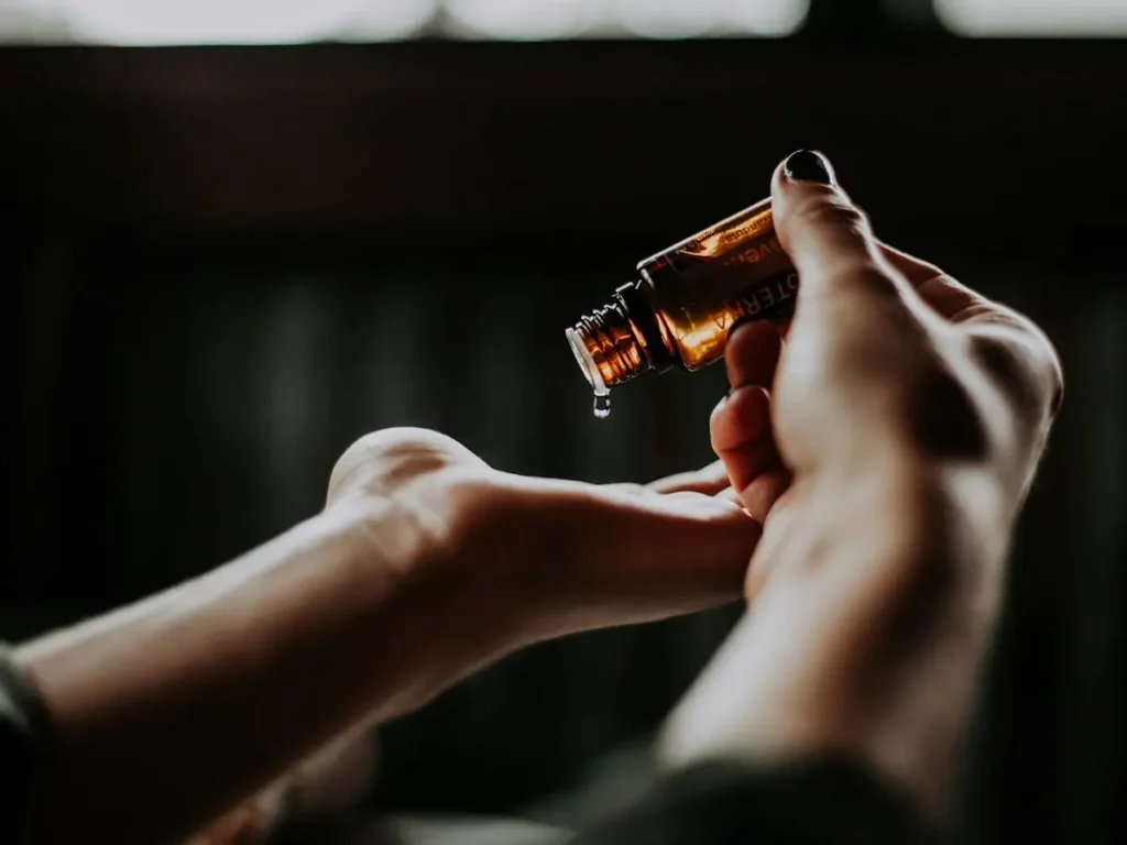 Hands holding a dropper bottle of herbal oil