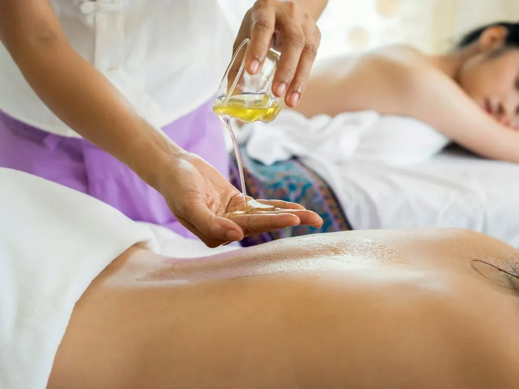 Therapist pouring warm oil for an Ayurvedic massage