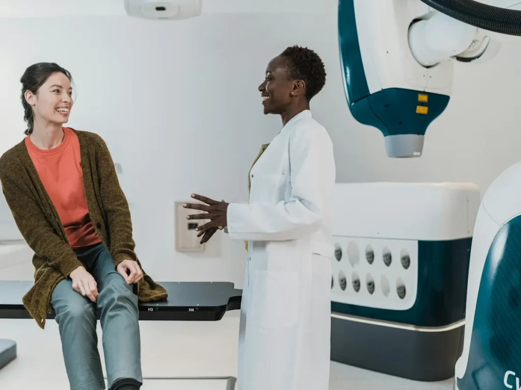 Clinician talking with a smiling patient in a treatment room